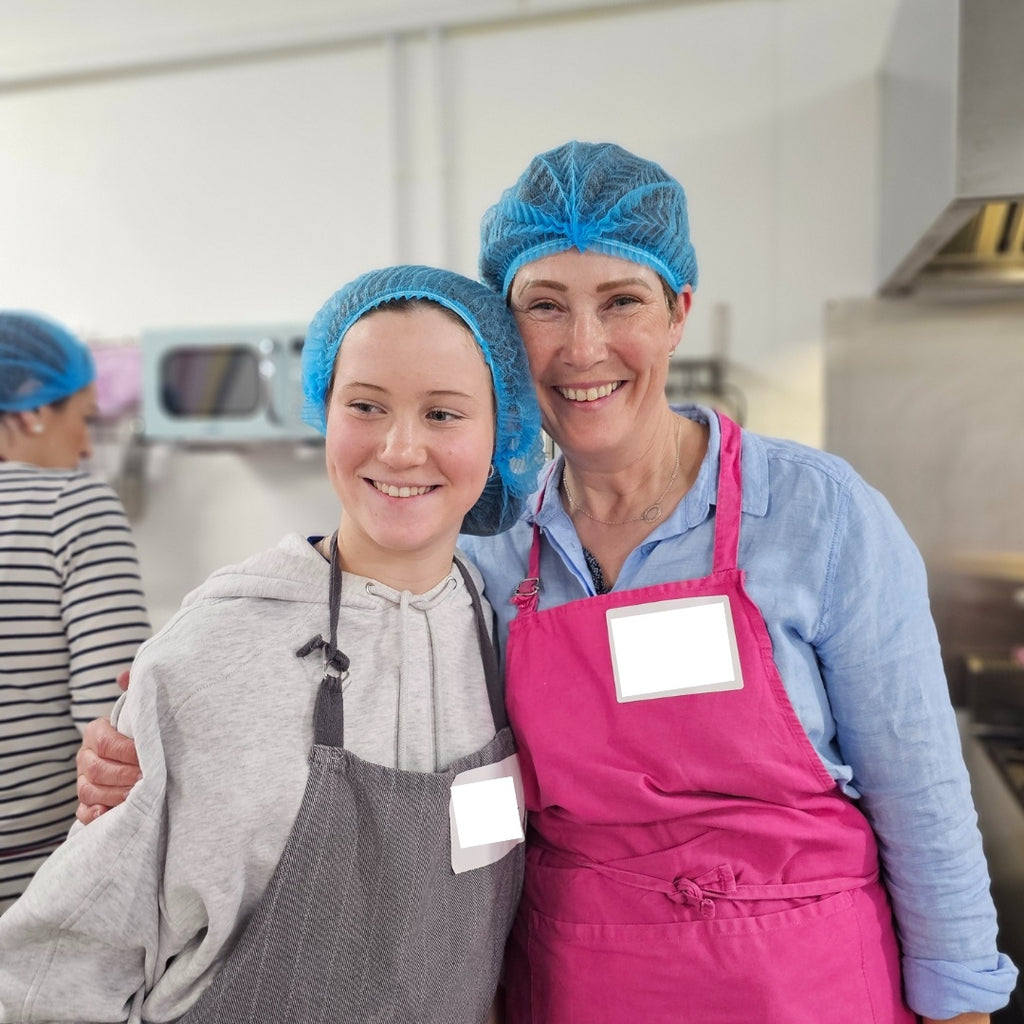 woman and girl with aprons and hairnets 